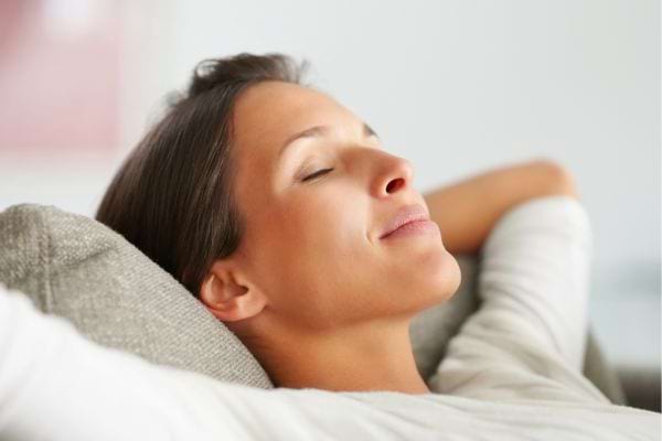Femme allongée, paisible et détendue.
