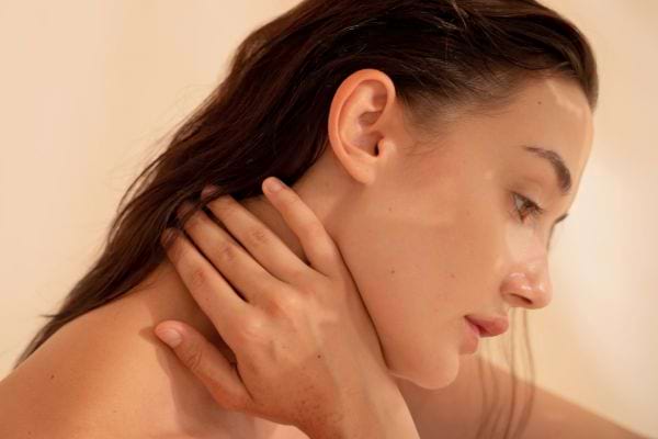Femme se massant doucement la nuque.