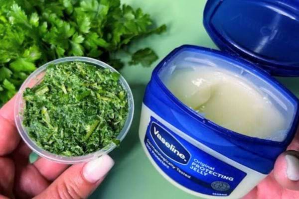 Mélange maison de persil haché et de Vaseline dans un pot.
