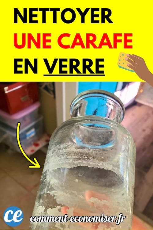 Carafe en verre entartrée tenue à la main, avec des traces blanches à l'intérieur.