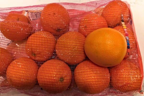 Filet rouge rempli d’oranges bien rondes.