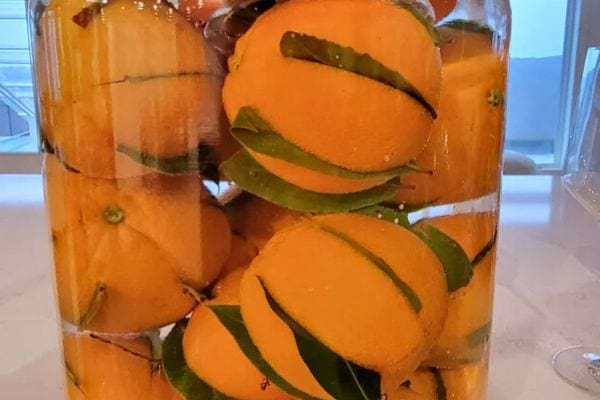 Oranges entières conservées dans un grand bocal.