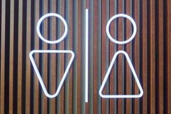 Panneau néon symbolisant toilettes homme et femme.