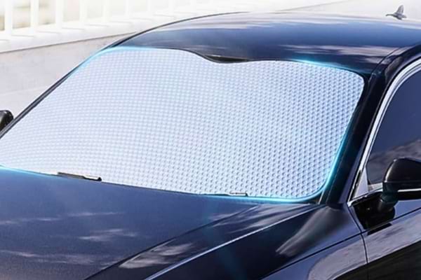 Pare-soleil installé sur le pare-brise d’une voiture noire pour bloquer la chaleur.