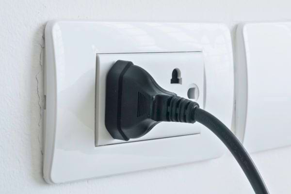 Une prise est insérée dans une prise murale.