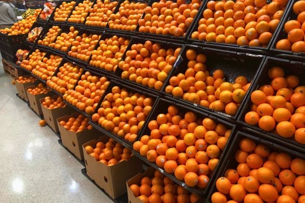 Rayon de supermarché débordant d’oranges.