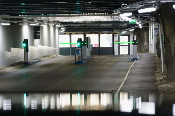 Sortie de parking souterrain avec feux verts allumés.