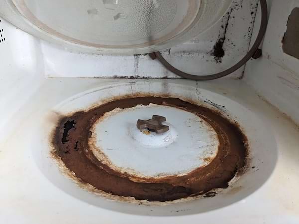 Le dessous d'un support de plateau tournant en verre dans un vieux micro-ondes