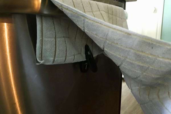 Torchon maintenu par des pinces sur la porte du four.