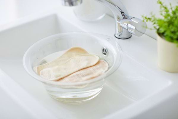 Trempage de torchons clairs dans une bassine d’eau.