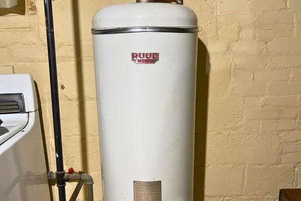 Modèle ancien RUUD blanc placé près d’un mur en brique.