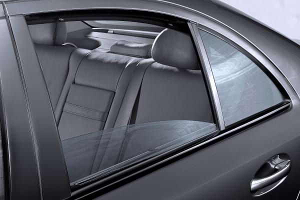 Zoom sur une vitre arrière entrouverte pour laisser passer l’air.