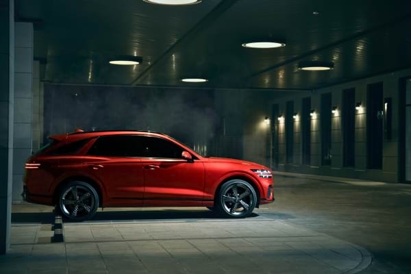 SUV rouge garé dans un parking couvert, prêt à rouler de nuit.