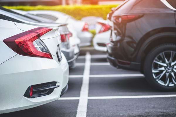 Voitures garées côte à côte en extérieur, vues de l’arrière.