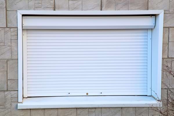 Volet roulant baissé sur une fenêtre extérieure.