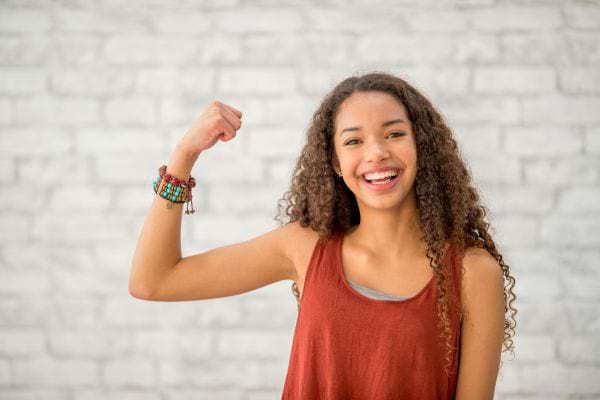 Jeune fille souriante montrant ses muscles.