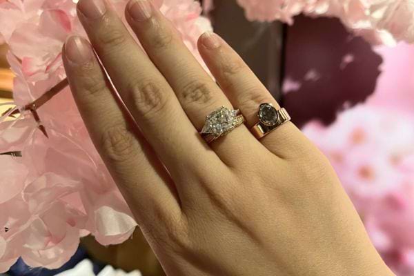 Trois bagues, dont une au petit doigt, main féminine.