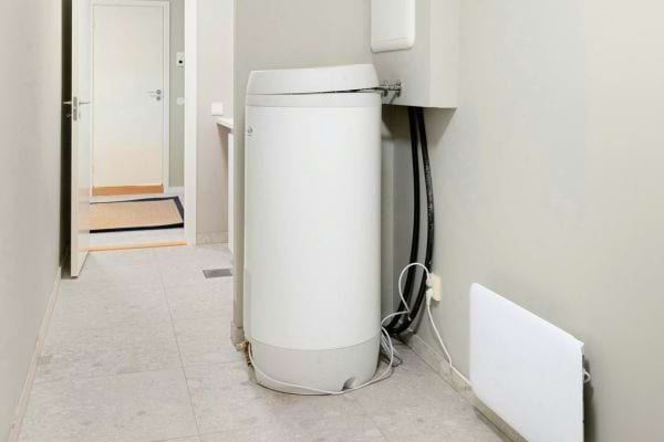 Ballon d’eau chaude installé dans un couloir étroit.