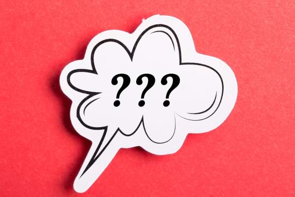 Bulle dessinée avec trois points d'interrogation noirs sur fond rouge.