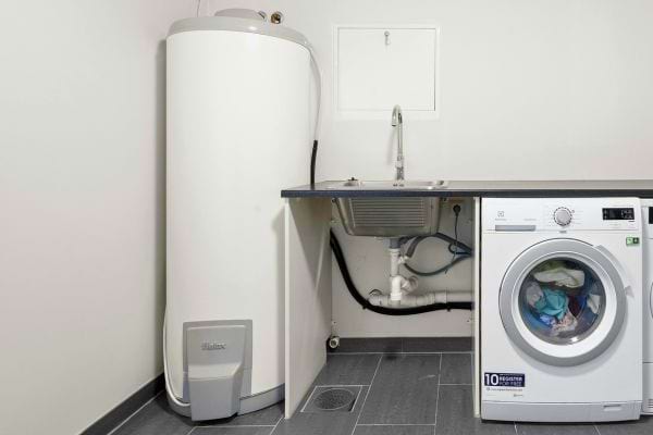 Chauffe-eau sous évier à côté d’un lave-linge.