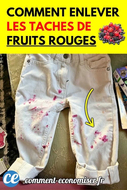 Un pantalon blanc avec des taches rouges de fruits rouges sur les jambes, posé sur un lit.