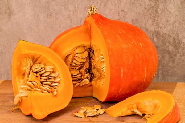 Potiron orange coupé en morceaux avec graines visibles.