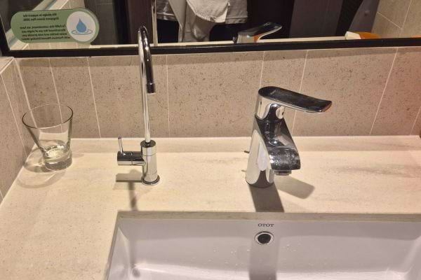 Lavabo avec un second robinet inhabituel, pouvant cacher un dispositif douteux.