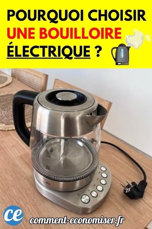 Bouilloire électrique en verre et acier posée sur une table en bois, avec la prise débranchée visible.