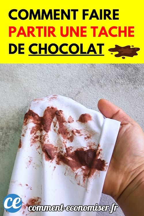 Une main tenant un tissu blanc taché de chocolat sur toute sa surface.