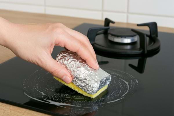 Éponge aluminium utilisée pour nettoyer une plaque de cuisson.