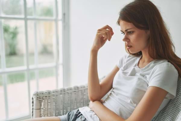 Une femme semble préoccupée par un problème de santé.