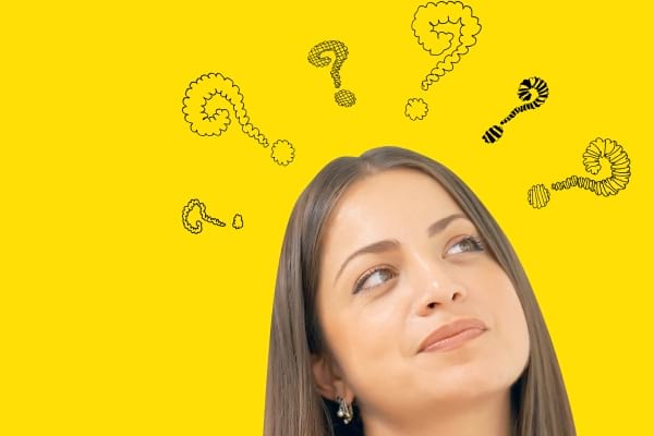 Femme pensive sur fond jaune, entourée de points d'interrogation dessinés.