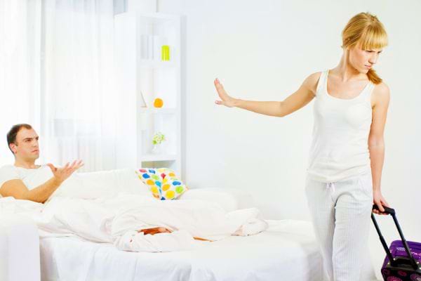 Une femme quitte un homme, valise &agrave; la main.