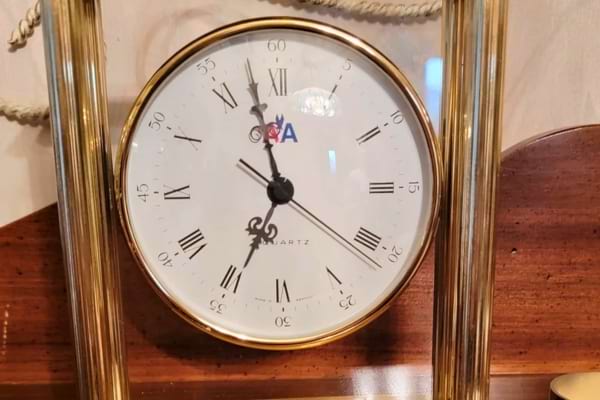 Horloge ancienne en verre et laiton indiquant minuit pile.