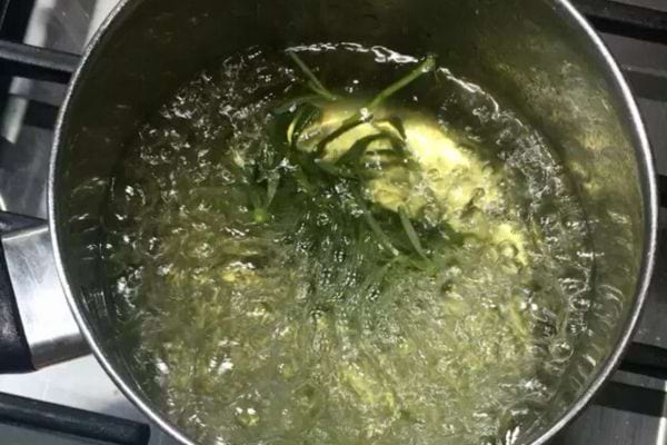 Romarin en train de bouillir dans une casserole d’eau chaude.