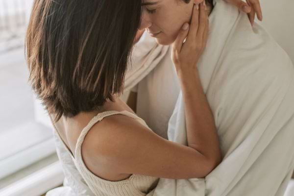 Couple enlacé tendrement, partageant un regard intime.