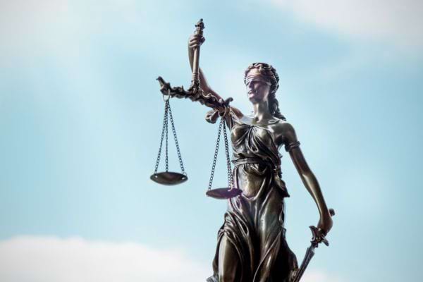 Une statue symbolise la justice avec une balance et une épée.