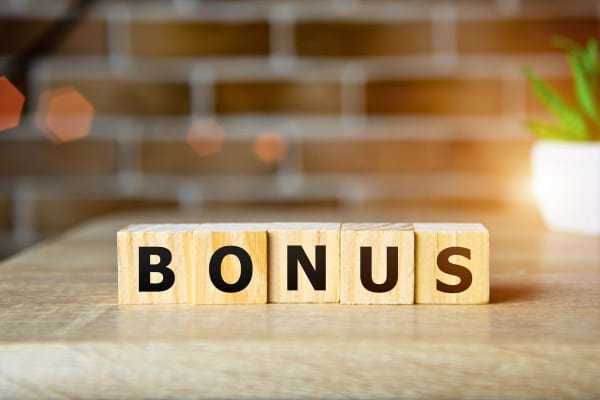 Le mot BONUS écrit sur des cubes en bois sur une table.