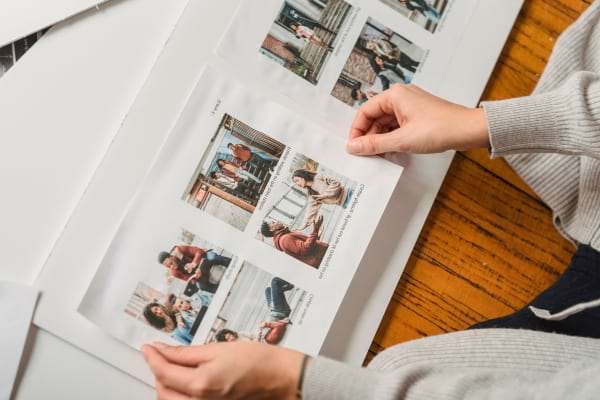 Mains feuilletant un album photo avec des souvenirs en images.