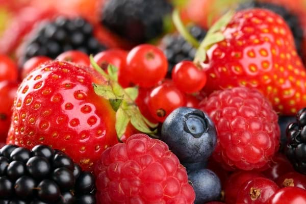 Mélange coloré de fruits rouges : fraises, framboises, mûres, myrtilles.