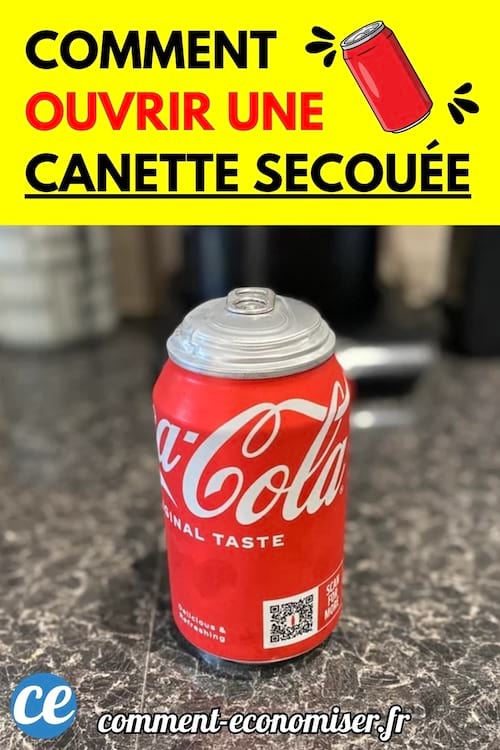 Une canette de Coca-Cola posée sur un plan de travail, avec le haut bombé comme si elle avait été secouée.