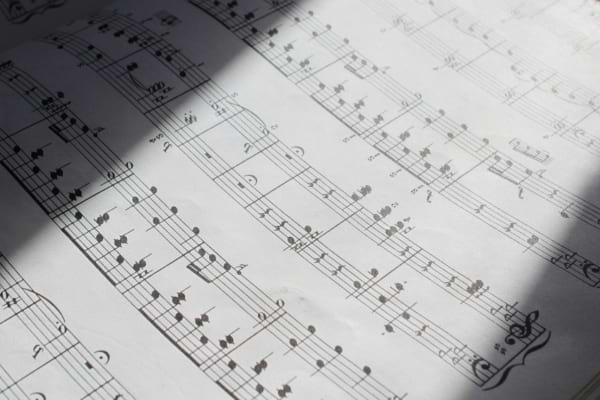 Une partition musicale détaillée est éclairée par une lumière naturelle.
