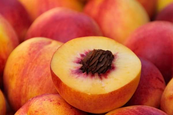 Une pêche coupée en deux révèle son noyau.