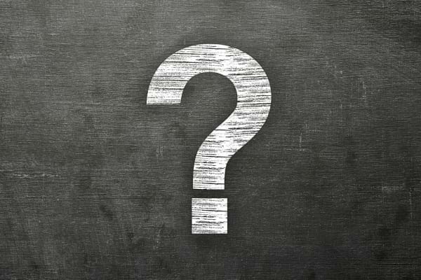 Un grand point d’interrogation blanc est dessiné sur un tableau noir.