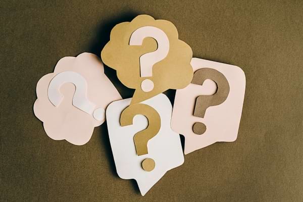 Quatre bulles en papier avec des points d’interrogation pour symboliser une question ou un problème à résoudre.