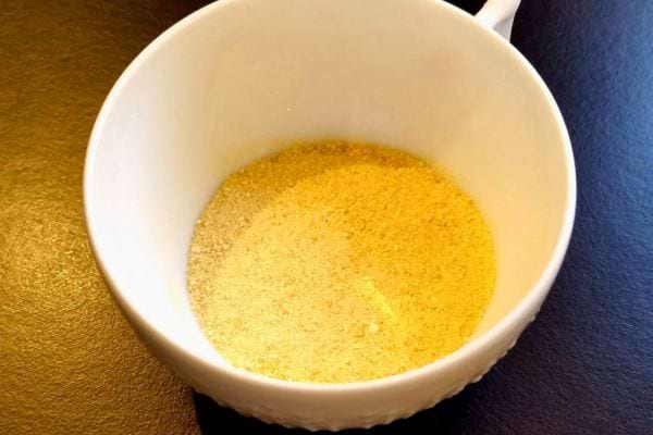 Une tasse blanche contenant de la poudre de citron.