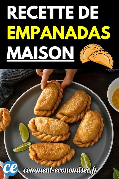Une assiette grise remplie d'empanadas dorées, avec des quartiers de citron vert et une main attrapant une pièce.