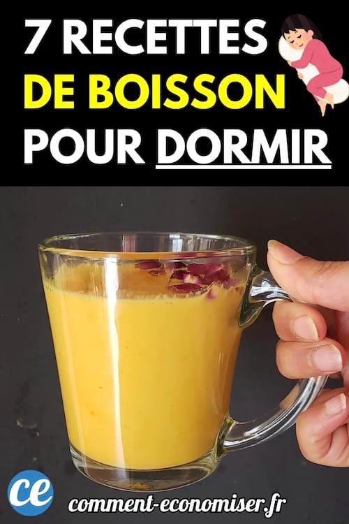 Une main tient une tasse en verre remplie d'une boisson jaune décorée de pétales.