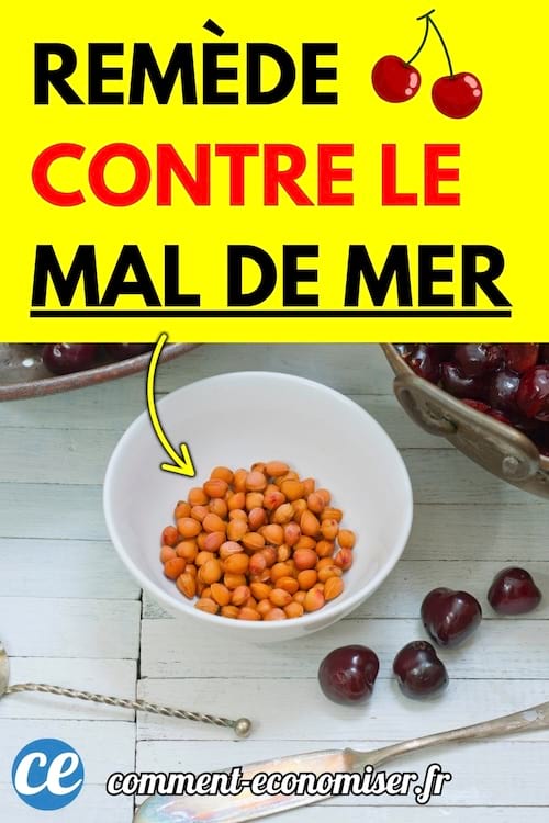 Un bol de petites baies orange sur une table en bois blanc, entouré de cerises noires.