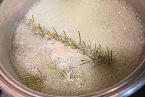 Branche de romarin infusée dans de l’eau bouillante.